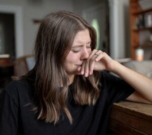 A woman cries as she considers scheduling PTSD treatment near Orlando