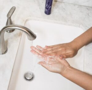 A woman with OCD washes her hands, in need of med management in Florida